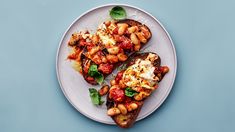 two pieces of toast with beans and spinach on a white plate against a blue background