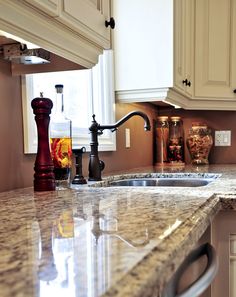 a kitchen with marble counter tops and white cabinets