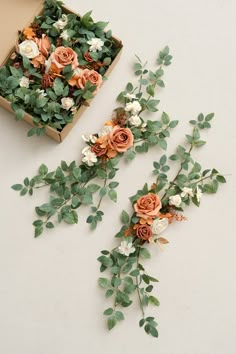 two boxes filled with flowers and greenery next to each other