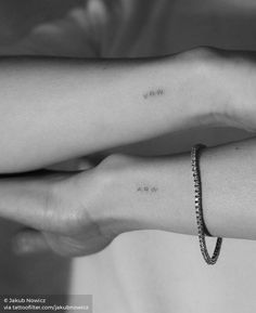 two hands holding each other with the word love on their wrist and one has a diamond bracelet