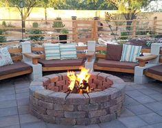 a fire pit surrounded by wooden benches and pillows