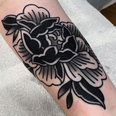 a black and white flower tattoo on the arm