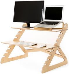 two computers are sitting on a wooden desk