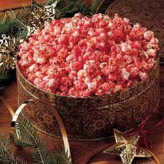 a large bowl filled with popcorn on top of a wooden table next to christmas decorations