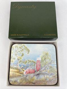 two coasters in a box with an image of a red bird on a tree branch