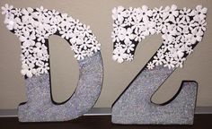 the letters d and f are made out of paper flowers on glittery silver foil