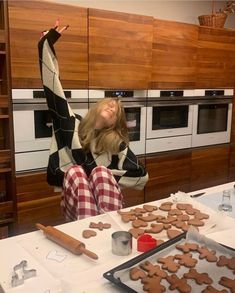 a woman sitting at a table with cookies on it