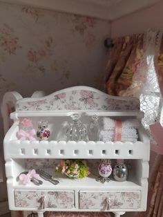 a white dollhouse furniture set with pink flowers and accessories on it's shelf