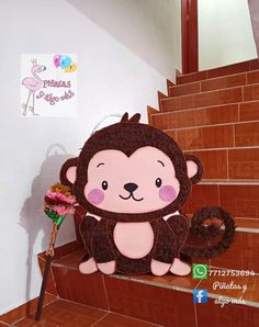 a stuffed monkey sitting on top of some stairs with a flower in it's hand