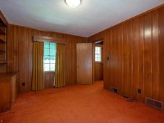 an empty room with wood paneling and carpeted walls is pictured in this image