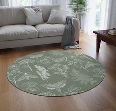 a living room with a white couch and green rug on the floor next to a window