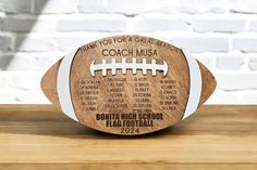 a wooden football with the names of each team on it