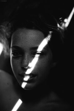 a woman with freckles on her face is shown in black and white photo