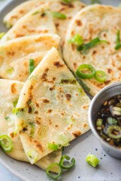 several flatbreads on a plate with dipping sauce