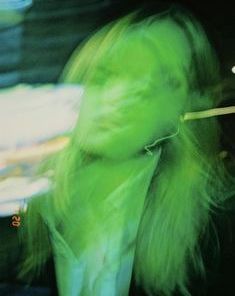 a blurry photo of a woman with green hair