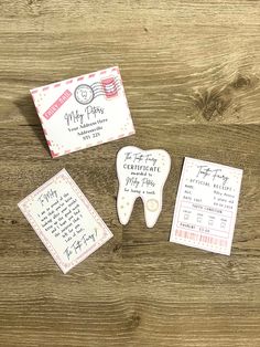 three tooth shaped magnets sitting on top of a wooden table next to a card