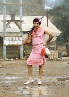 a man in a pink dress holding a baseball bat