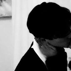 a man and woman kissing each other in black and white