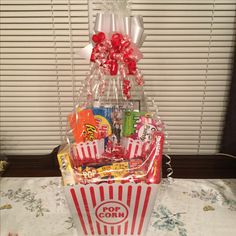 a popcorn bucket filled with candy, candies and lollipops on a table