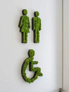 three sculptures made to look like people with grass growing out of them on the wall