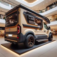 the rear end of an rv parked in a mall with its doors open and lights on