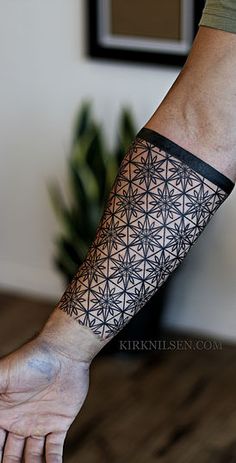 a man's arm with a tattoo on it that has geometric shapes and lines