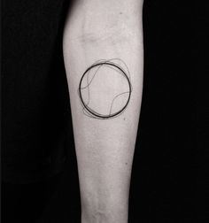 a black and white photo of a person's leg with a circle tattoo on it