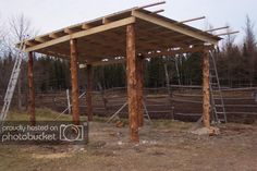 a large wooden structure sitting in the middle of a field