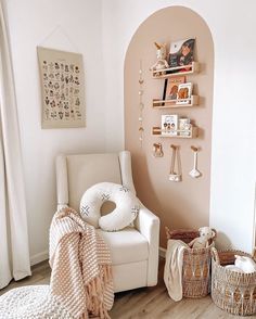 a white chair sitting in a living room next to a wall filled with pictures and toys