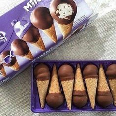 chocolate covered ice cream cones in a purple box next to a package of milk caramels