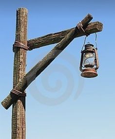 an old wooden pole with a lantern hanging from it