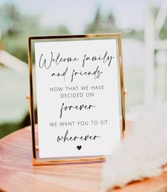 a sign that is on top of a wooden table next to a white and black feather