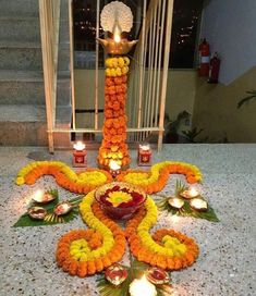 an elaborate arrangement of flowers and candles on the ground