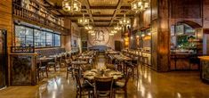 the inside of a restaurant with tables, chairs and chandeliers hanging from the ceiling