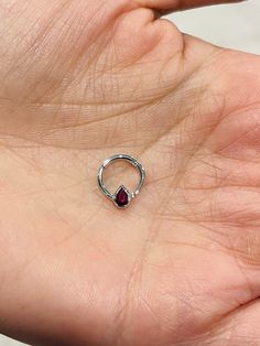 a woman's hand with a ring on it and a red stone in the middle