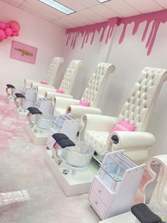 a row of white chairs with pink decorations on them