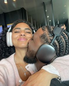 a man kissing a woman with headphones on