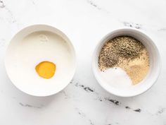 two bowls filled with different types of spices on top of a white countertop next to each other