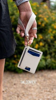 a person is holding a wallet with a lanyard attached to it