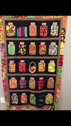 a quilted wall hanging with lots of food on it's sides and jars