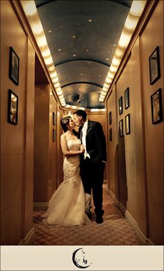 a bride and groom kissing in the hallway of their wedding reception at disney's grand california hotel