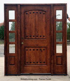 a large wooden door with two sidelights