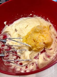 a red bowl filled with cream and other ingredients