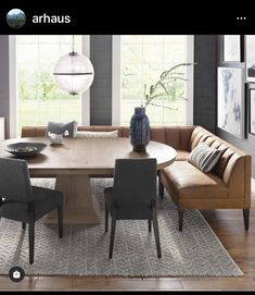 a large wooden table with chairs around it in a living room next to a couch