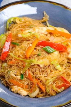 a blue plate topped with noodles and vegetables