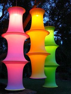 three tall, multicolored lights are lit up in the dark