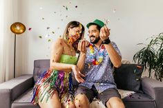 a man and woman sitting on a couch with confetti all over them