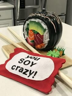 there is a sushi and chopsticks on the table with a sign that says you soy crazy