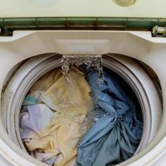 an open washing machine with clothes in it