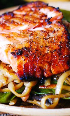 a close up of a plate of food with meat and noodles on it's side